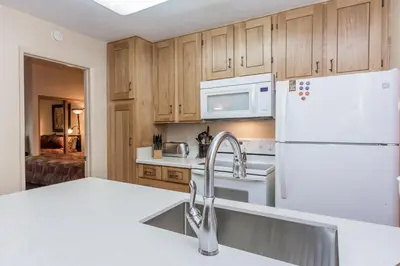 a kitchen with a white refrigerator and a sink at Crestview -B # 46 in Mammoth Lakes