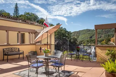 a patio with chairs and a table with an umbrella at Historic Sonora Inn in Sonora
