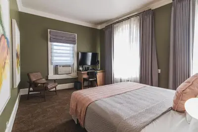 a bedroom with a bed and a desk and a television at Historic Sonora Inn in Sonora