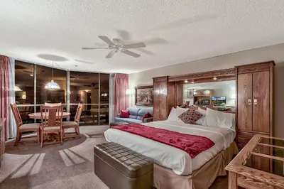 a bedroom with a large bed and a dining room at Plaza Resort Club Reno in Reno