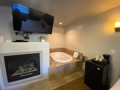 a bathroom with a fireplace and a tv above a tub at Secrets Inn Lake Tahoe in South Lake Tahoe