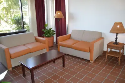 a living room with two chairs and a coffee table at Motel 6 Oakdale, Ca in Oakdale