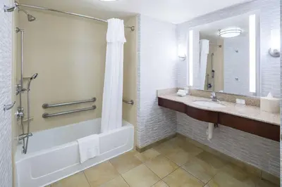 a bathroom with a tub and a sink and a mirror at Homewood Suites by Hilton Fresno Airport/Clovis in Clovis