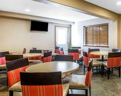 a waiting room with tables and chairs and a tv at Quality Inn Lone Pine near Mount Whitney in Lone Pine
