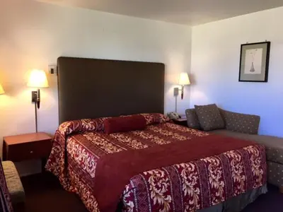 a hotel room with a bed and a couch at Maple Inn and Suites Los Banos in Los Banos