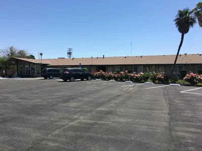 a parking lot in front of a building at Maple Inn and Suites Los Banos in Los Banos