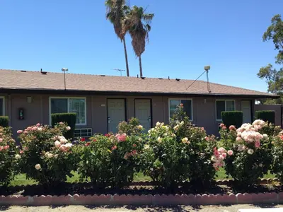 a house with flowers in front of it at Maple Inn and Suites Los Banos in Los Banos