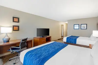 a hotel room with two beds and a desk and a television at Comfort Inn & Suites Rocklin - Roseville in Rocklin