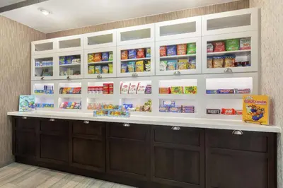 a pharmacyacistacistacist counter with cabinets and food on the shelves at Homewood Suites by Hilton Sacramento/Roseville in Roseville