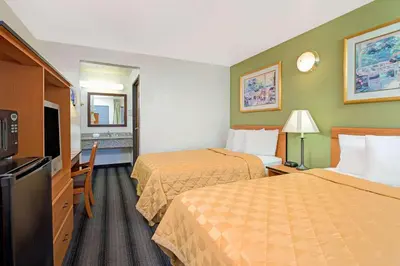 a hotel room with two beds and a television at Travelodge by Wyndham Sacramento / Rancho Cordova in Sacramento