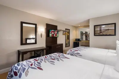 a hotel room with two beds and a desk at Red Roof Inn Stockton in Stockton