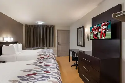 a hotel room with a bed and a flat screen tv at Red Roof Inn Stockton in Stockton
