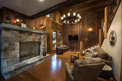 a living room with a stone fireplace in a house at 1R Rustic Retreat in Wawona
