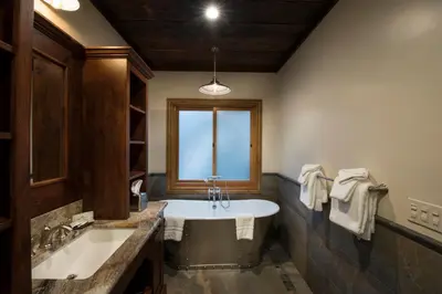 a bathroom with a tub and a sink and a window at 1R Rustic Retreat in Wawona