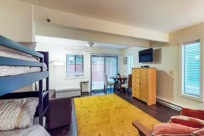 a bedroom with a bunk bed and a living room at Casa del Lago in Tyrolian Village