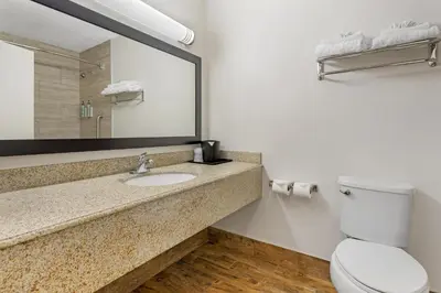 a bathroom with a sink and a toilet and a mirror at Best Western Kettleman City Inn & Suites in Kettleman City