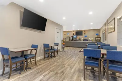 a waiting room with tables and chairs and a flat screen tv at Best Western Kettleman City Inn & Suites in Kettleman City