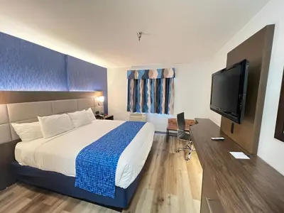 a hotel room with a bed and a flat screen tv at SureStay Plus Hotel by Best Western Mammoth Lakes in Mammoth Lakes