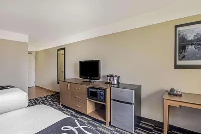 a hotel room with a bed and a flat screen tv at La Quinta by Wyndham Modesto Salida in Modesto