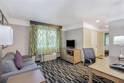 a living room with a couch and a tv and a desk at La Quinta by Wyndham Modesto Salida in Modesto