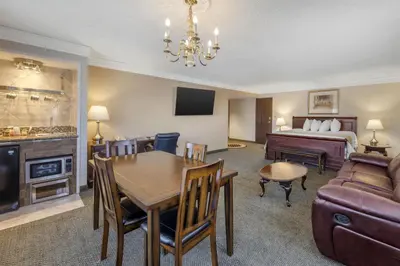 a living room with a bed and a dining room at SureStay Plus Hotel by Best Western Reno Airport in Reno