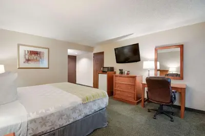 a hotel room with a bed and a desk and a chair at SureStay Plus Hotel by Best Western Reno Airport in Reno