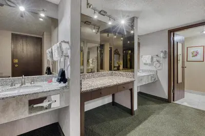 a bathroom with two sinks and a large mirror at SureStay Plus Hotel by Best Western Reno Airport in Reno