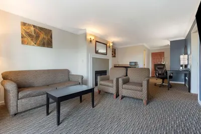 a living room with a couch and chairs and a desk at Best Western Colonial Inn in Selma