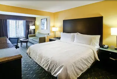 a hotel room with a large bed and a couch at Holiday Inn Express Hotel & Suites San Jose-Morgan Hill by IHG in Morgan Hill