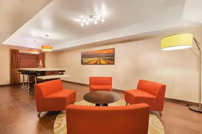 a waiting room with orange chairs and a piano at Holiday Inn Express Hotel & Suites San Jose-Morgan Hill by IHG in Morgan Hill