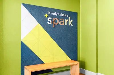 a wall with a sign that reads it only takes a spark at Spark by Hilton Modesto in Modesto