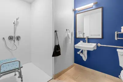 a blue bathroom with a sink and a mirror at Spark by Hilton Modesto in Modesto