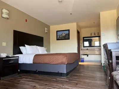 a hotel room with a bed and a bathroom at Yosemite Sierra Inn in Oakhurst