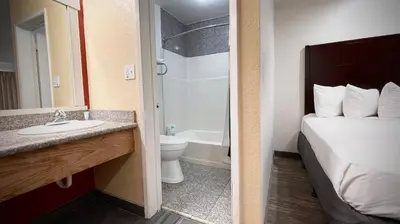 a bathroom with a bed and a sink and a toilet at The Yosemite Inn in Mariposa