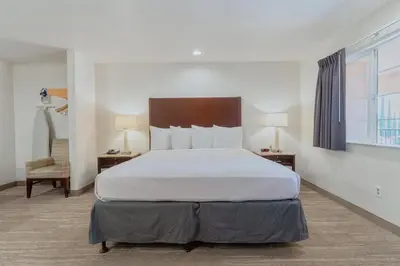 a bedroom with a large bed and a chair at The Yosemite Inn in Mariposa