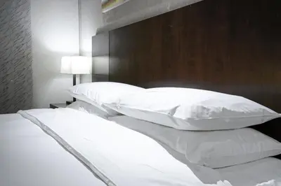 two beds with white pillows in a bedroom at The Yosemite Inn in Mariposa
