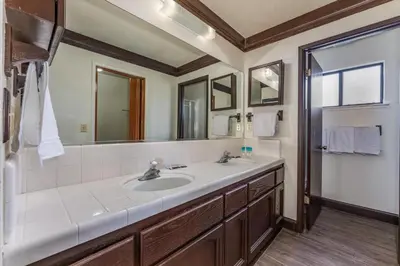 a bathroom with a sink and a mirror at Mountain Trail Lodge and Vacation Rentals in Oakhurst