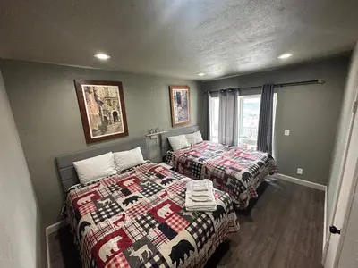 a bedroom with two beds and a window at Mountain Trail Lodge and Vacation Rentals in Oakhurst