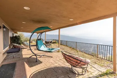 a porch with chairs and a view of the mountains at Mountain Trail Lodge and Vacation Rentals in Oakhurst