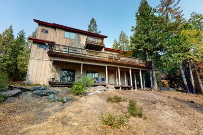 a large house on top of a hill with trees at Forest Falls in Shaver Lake