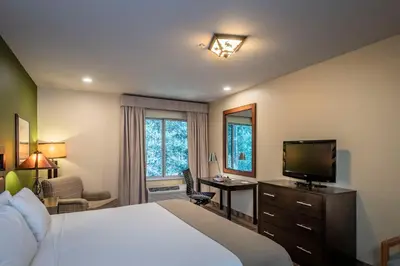 a bedroom with a bed with a television and a desk at Truckee Donner Lodge in Truckee