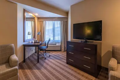 a hotel room with a desk and a flat screen tv at Truckee Donner Lodge in Truckee