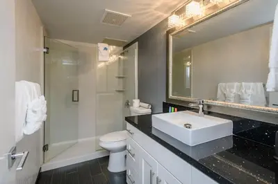 a bathroom with a sink and a toilet and a mirror at Lions Gate Hotel in Sacramento