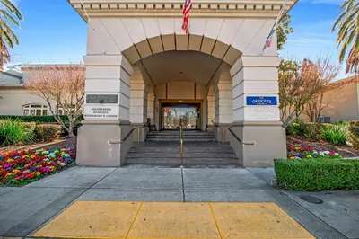 an entrance to a building with stairs and flowers at Lions Gate Hotel in Sacramento