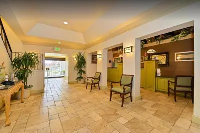 a lobby with chairs and a table in a building at Lions Gate Hotel in Sacramento