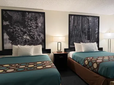 a hotel room with two beds and a painting on the wall at Super 8 by Wyndham Selma/Fresno Area in Selma