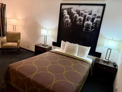 a hotel room with a bed and a chair at Super 8 by Wyndham Selma/Fresno Area in Selma