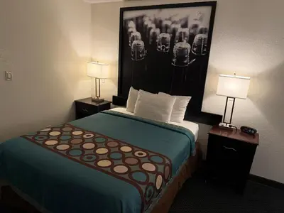 a hotel room with a bed with a picture on the wall at Super 8 by Wyndham Selma/Fresno Area in Selma