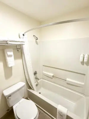 a bathroom with a toilet and a tub and a sink at Super 8 by Wyndham Selma/Fresno Area in Selma