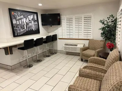 a waiting room with chairs and a flat screen tv at Super 8 by Wyndham Selma/Fresno Area in Selma